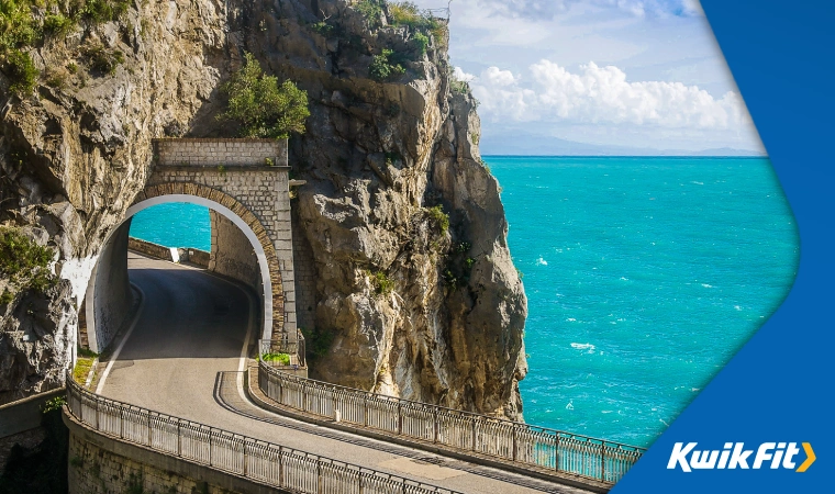 Deep blue sea in the background of a tunnel on Amalfi Drive, Italy.