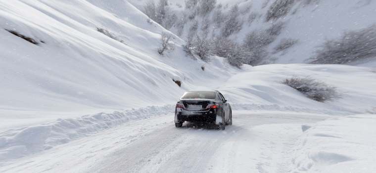 car on mountain road with snow