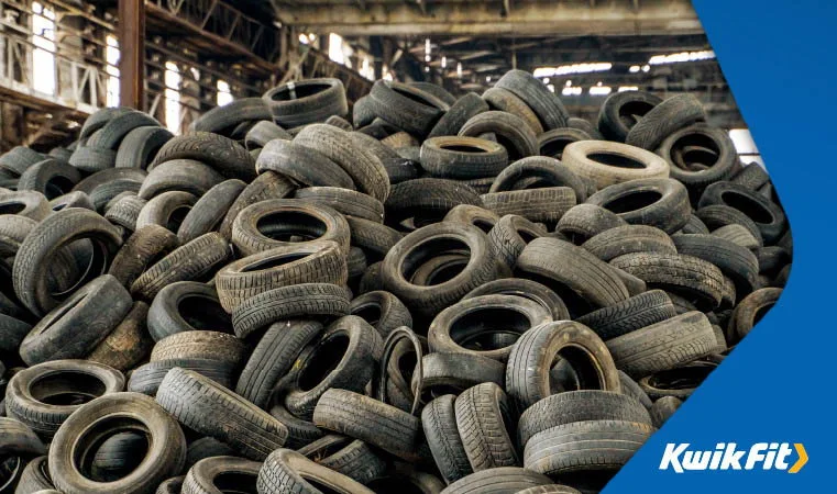 Large pile of wasted and used tyres at a garage.