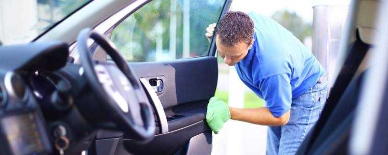 man cleaning inside of car