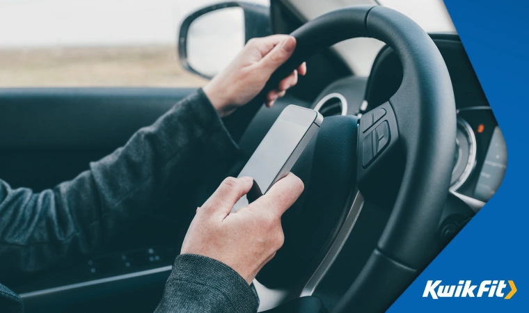 A driver uses their phone while at the wheel.