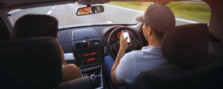 man using phone while driving