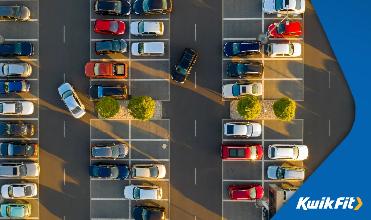 Aerial view of a large outdoor car park with multiple parked cars.