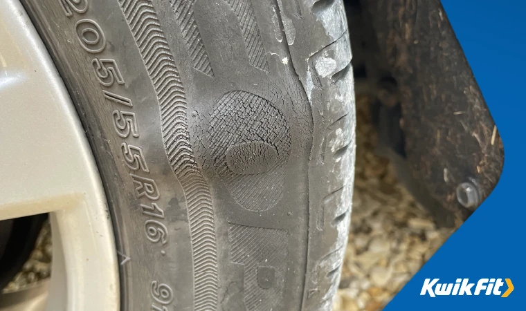 A bulge in a car tyre.