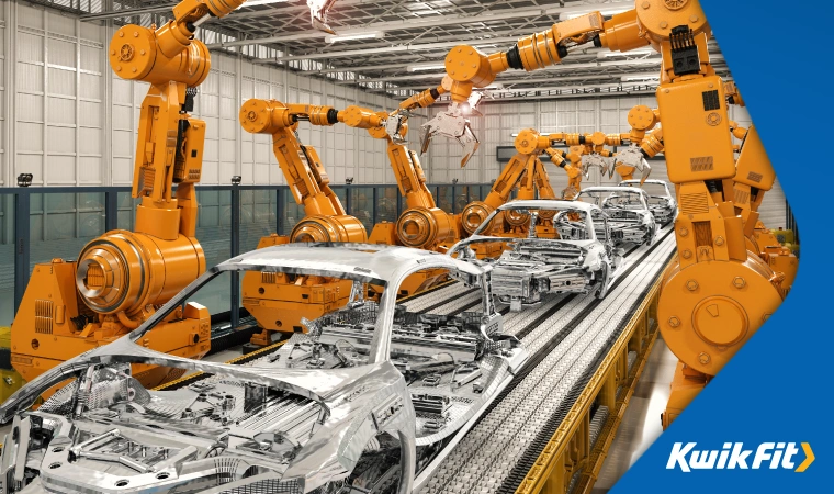 Cars on a manufacturing line are being assembled by robotic arms.