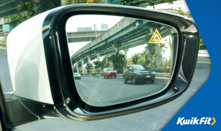 Close up of a car's side mirror showing cars overtaking.