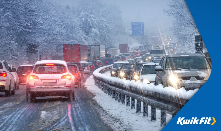 Cars backed up on an icy, snowy motorway.