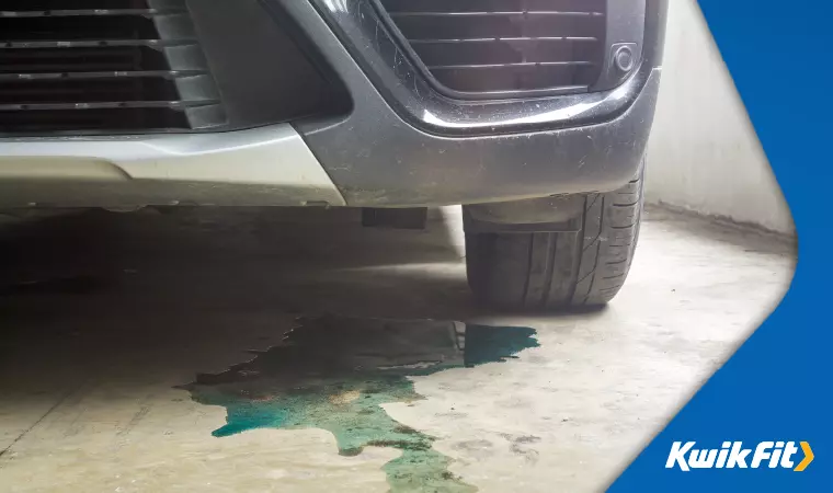 Blue-green coolant leaking from underneath a car.