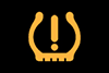 tyre pressure low warning light on car dashboard