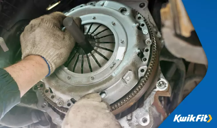 A technician tweaking a deconstructed clutch assembly.