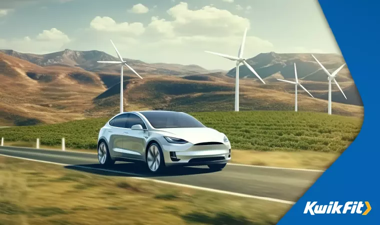 Concept image of a sleek electric vehicle driving on a road with green fields and wind turbines in the background.
