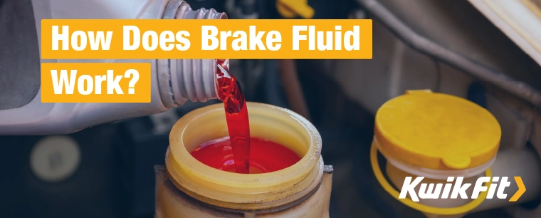 Red brake fluid being poured into a car's brake fluid reservoir.