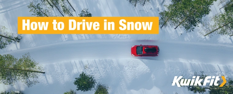 Bird's-eye view, a red car drives through thick snow on a clear, sunny day.