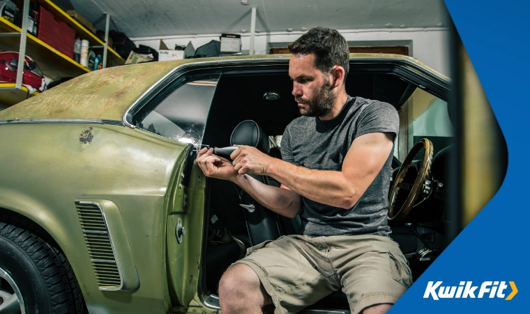 Car owner performing maintenance work on a classic car to avoid depreciation.