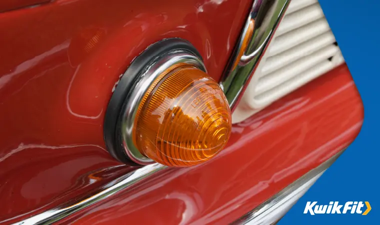 An indicator bulb on a classic red car.