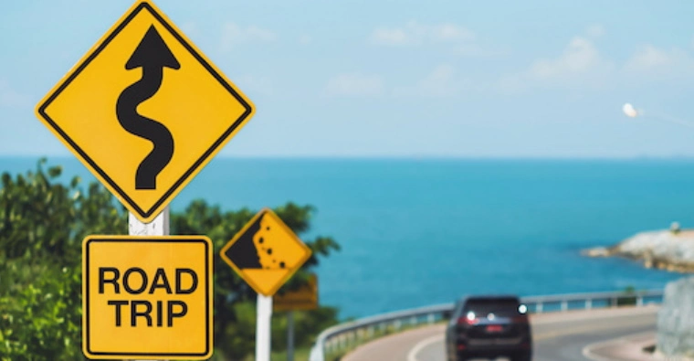 Road trip sign on a seaside highway