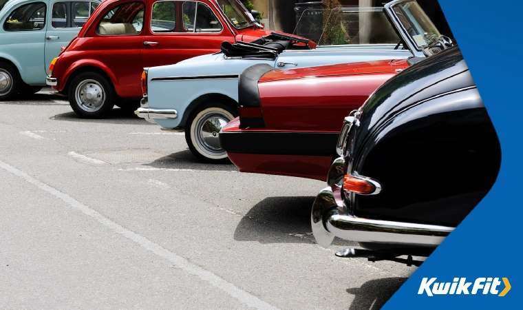 A row of classic cars parked up at a car s