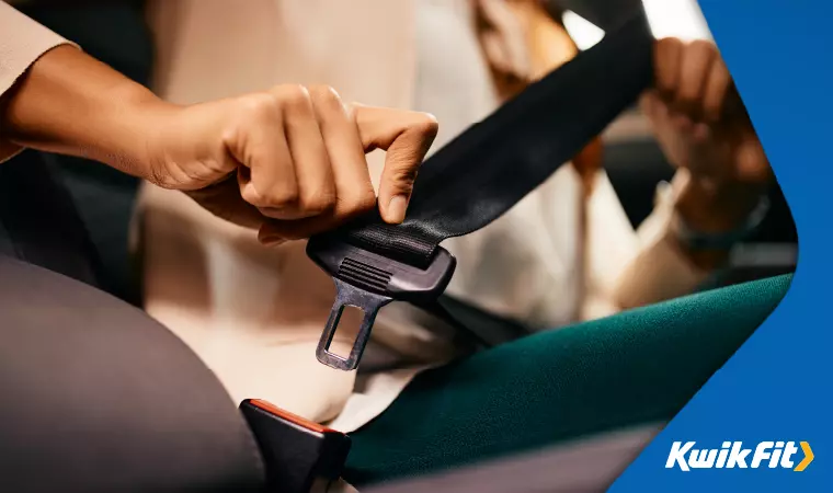 A car passenger about to fasten their seatbelt.