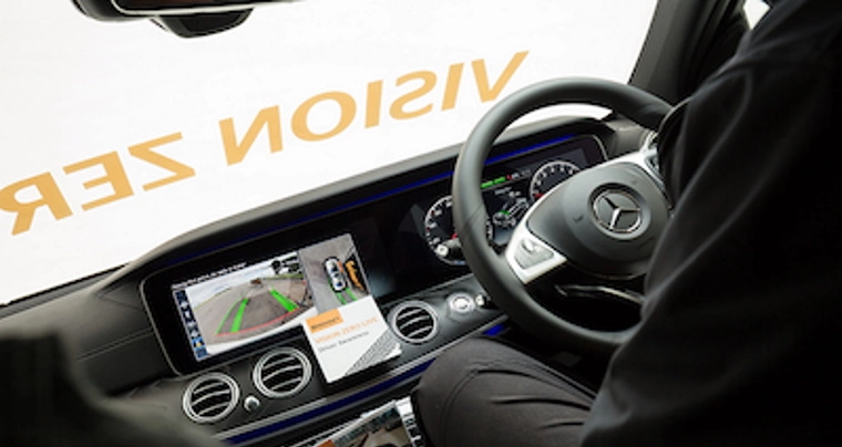 Person driving at Continental Vision Zero Live Event, with the dashboard of the Mercedes showing an assisted parking view.