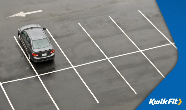 An empty car park with just one car in a space.