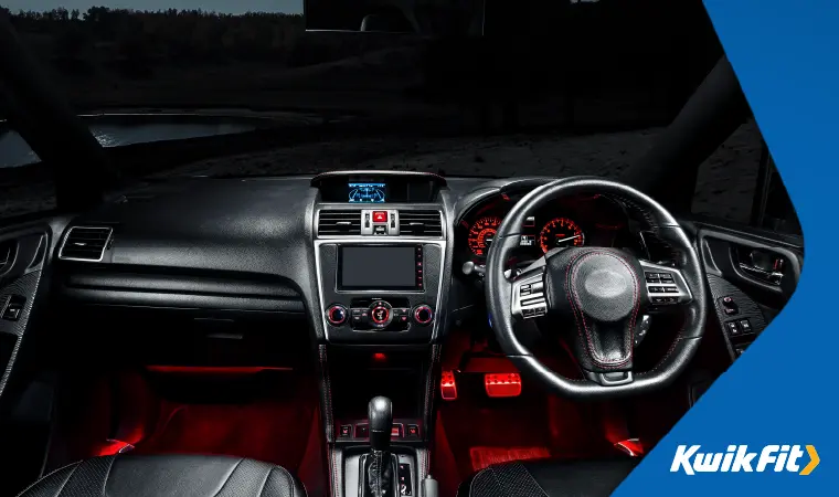 The sleek, modern, black and red dashboard of a car.