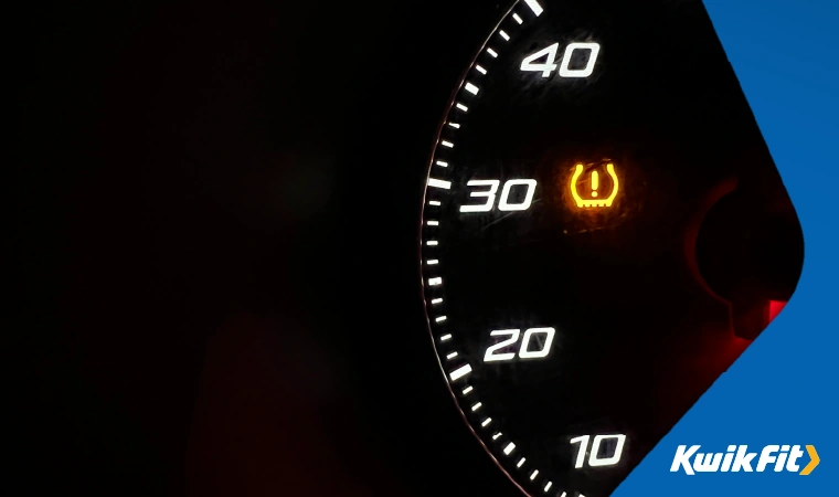 An orange tyre pressure warning light on a car dashboard.