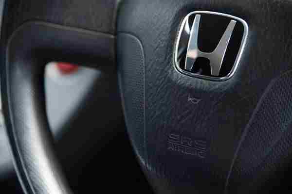 A car horn symbol on the steering wheel of a Honda car